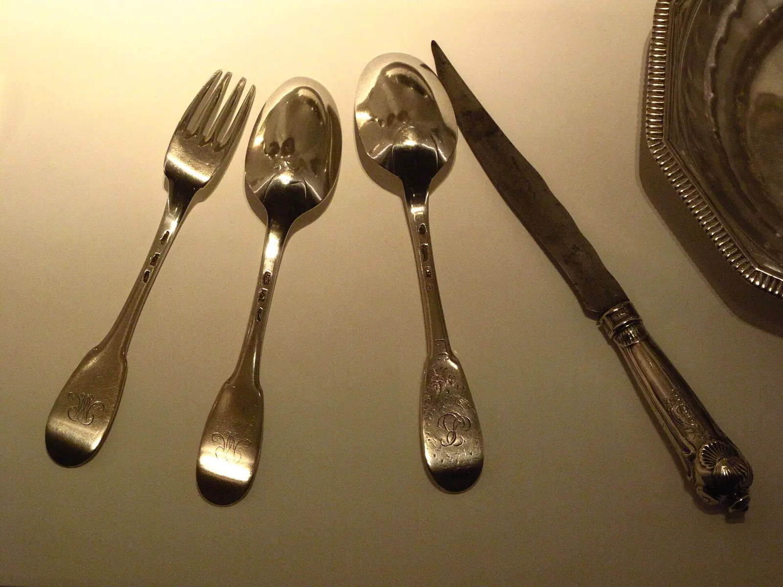 Cuillères, fourchette et couteau anciens en argent posés sur une table