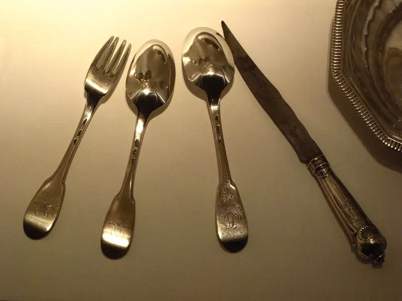 Cuillères, fourchette et couteau anciens en argent posés sur une table