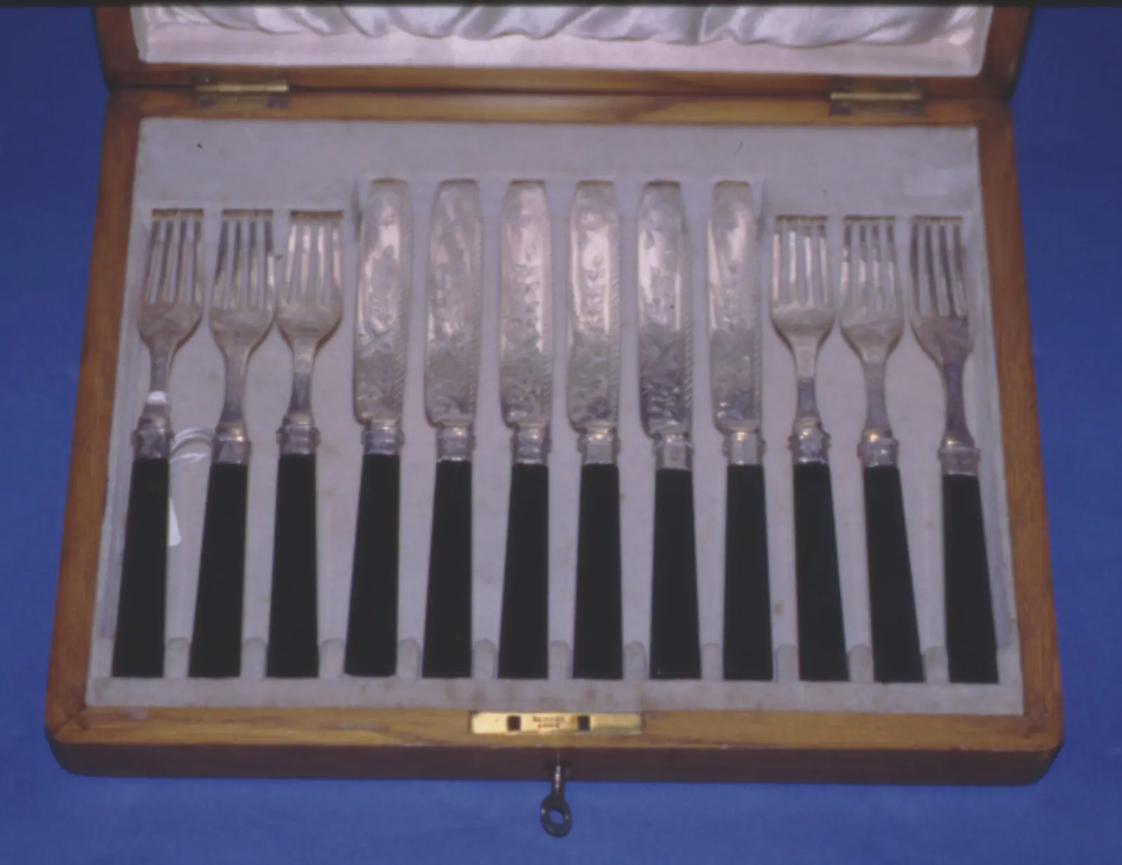 Ménagère de couteaux et fourchettes à dessert en argent dans son coffret en bois